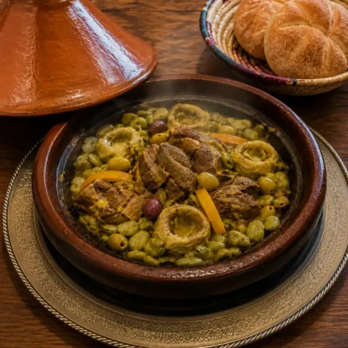 Beef Tagine Recipe with artichokes and fava beans served on a Moroccan tray with khobz bread basket