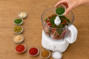 Sardines, herbs, garlic, and spices being blended in a food processor for moroccan fish balls tagine