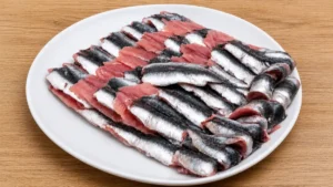 Cleaned and deboned sardines prepared for moroccan fish balls tagine on a white plate