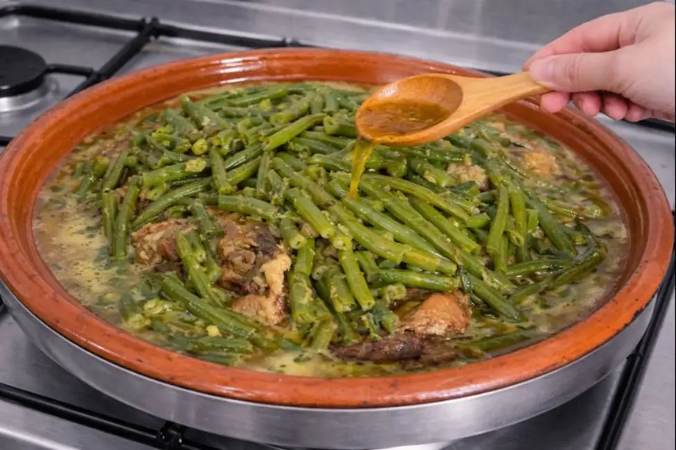 Moroccan tagine cooking with beef and green beans drenched in savory sauce.