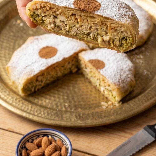 Moroccan Bastilla cut open with chicken, onion, egg, and almond filling