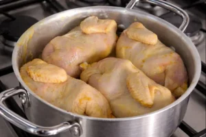 Cornish hens cooking in a pot for rfissa recipe on a stovetop