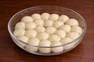 Oiled dough balls for trid used in rfissa recipe in a glass bowl