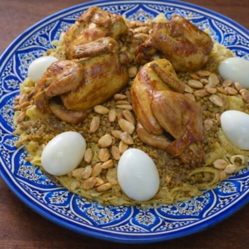 Rfissa recipe with chicken, lentils, and eggs served on a traditional Moroccan plate