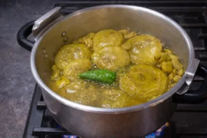 Artichokes and fava beans simmering gently without much stirring in a Vegetarian Tagine Recip
